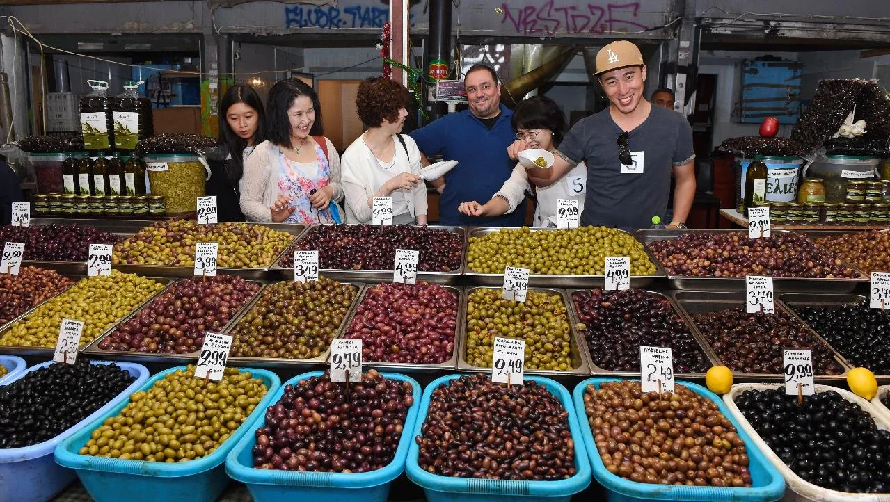 Participants sampling olives at an Athens market