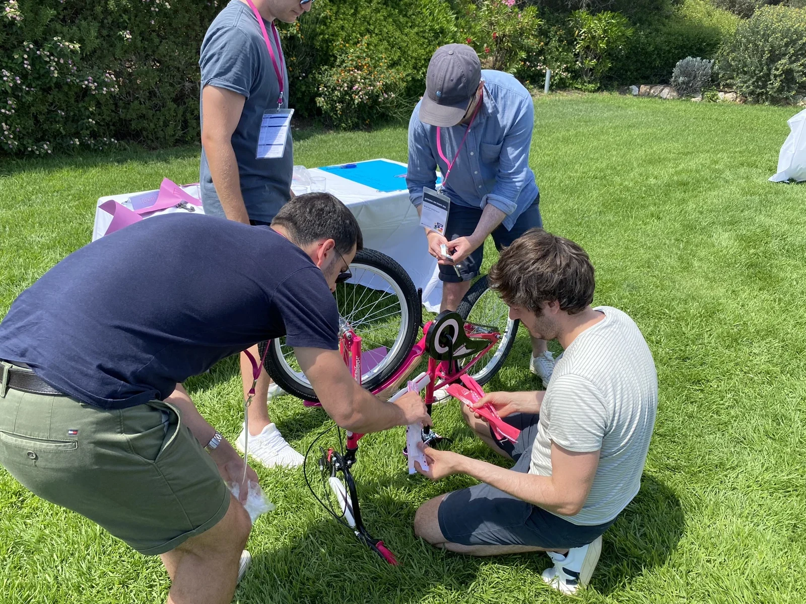Participants assembling a bicycle together outdoors