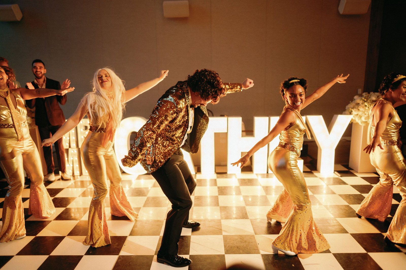 Dancers performing a disco routine at an evening event