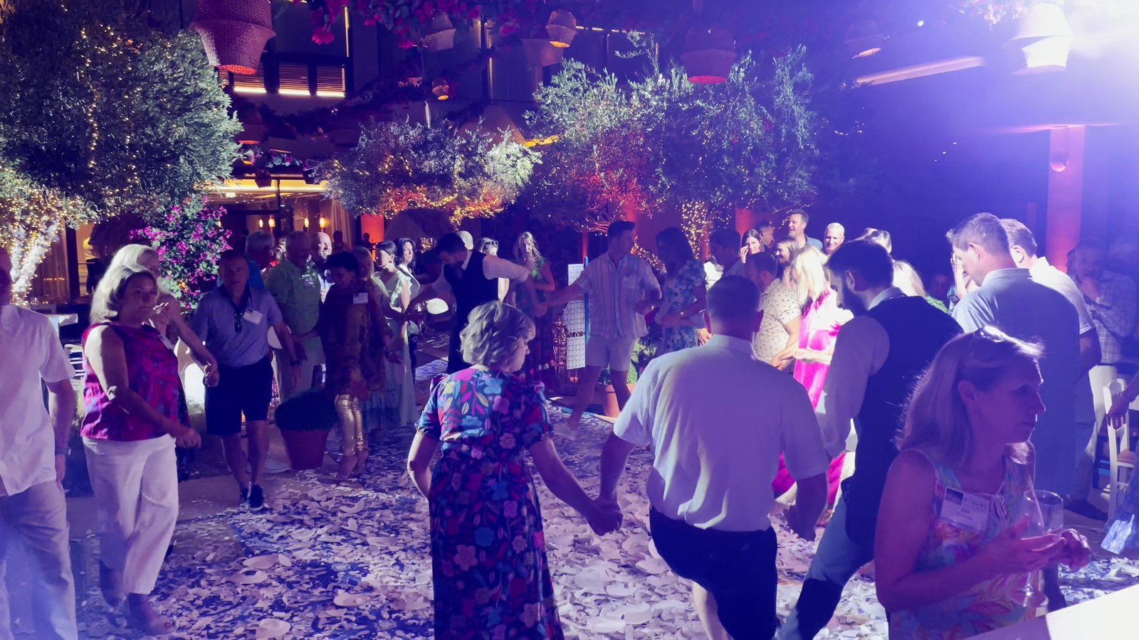 Guests joining a Greek dance at an evening celebration