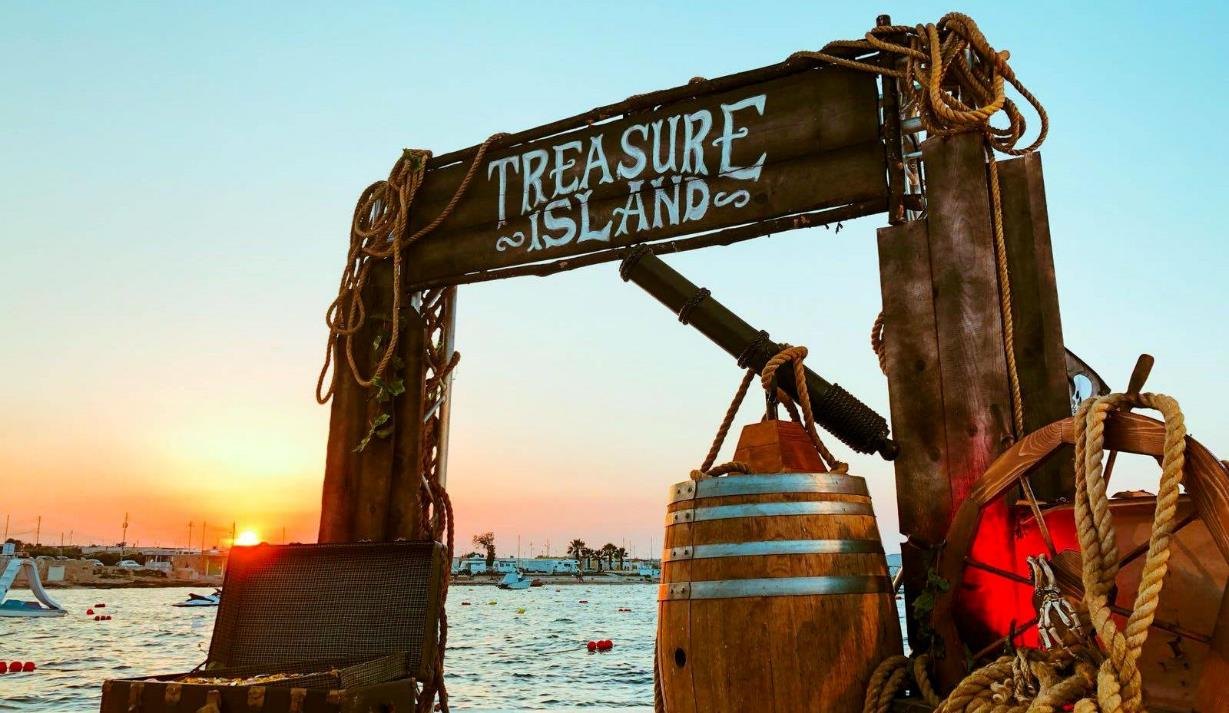 Pirate-themed entrance beside the sea at sunset