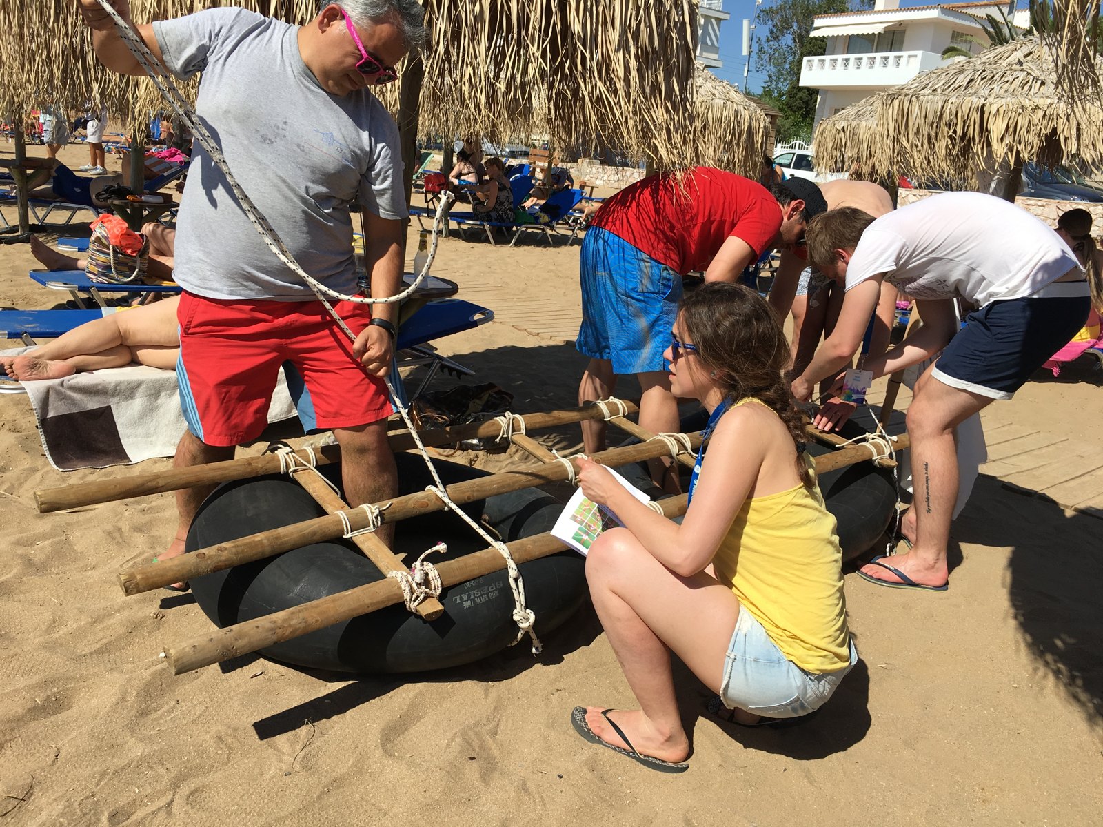A team assembling a raft on a beach