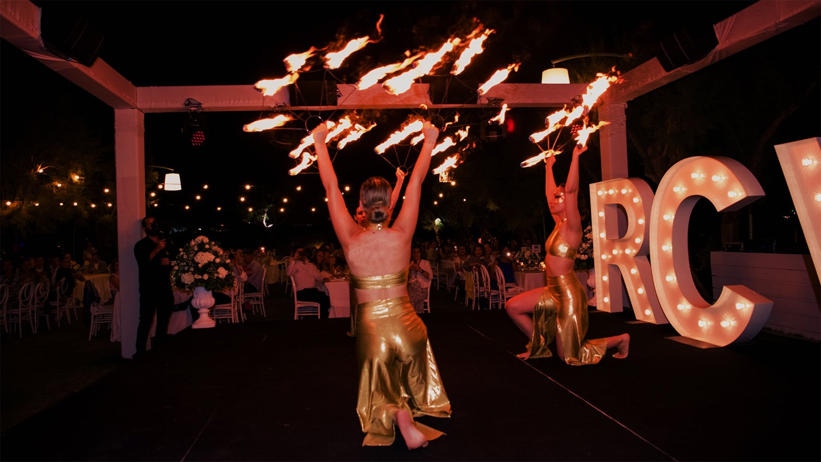 Fire performers in gold costumes on stage