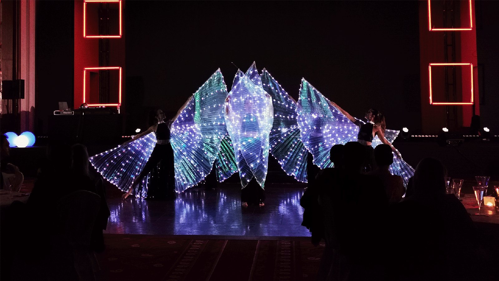 Dancers performing with illuminated wings