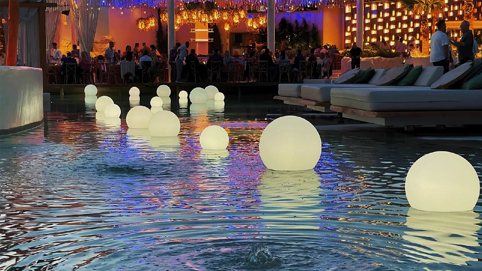 Glowing LED spheres floating in an event pool