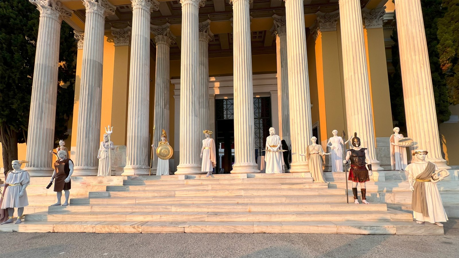 Living statues of Greek gods in front of a colonnade